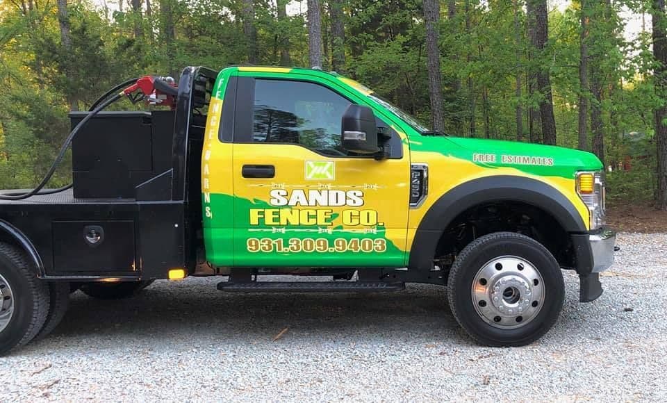 A Sands Fence Co. branded work truck on a job site
